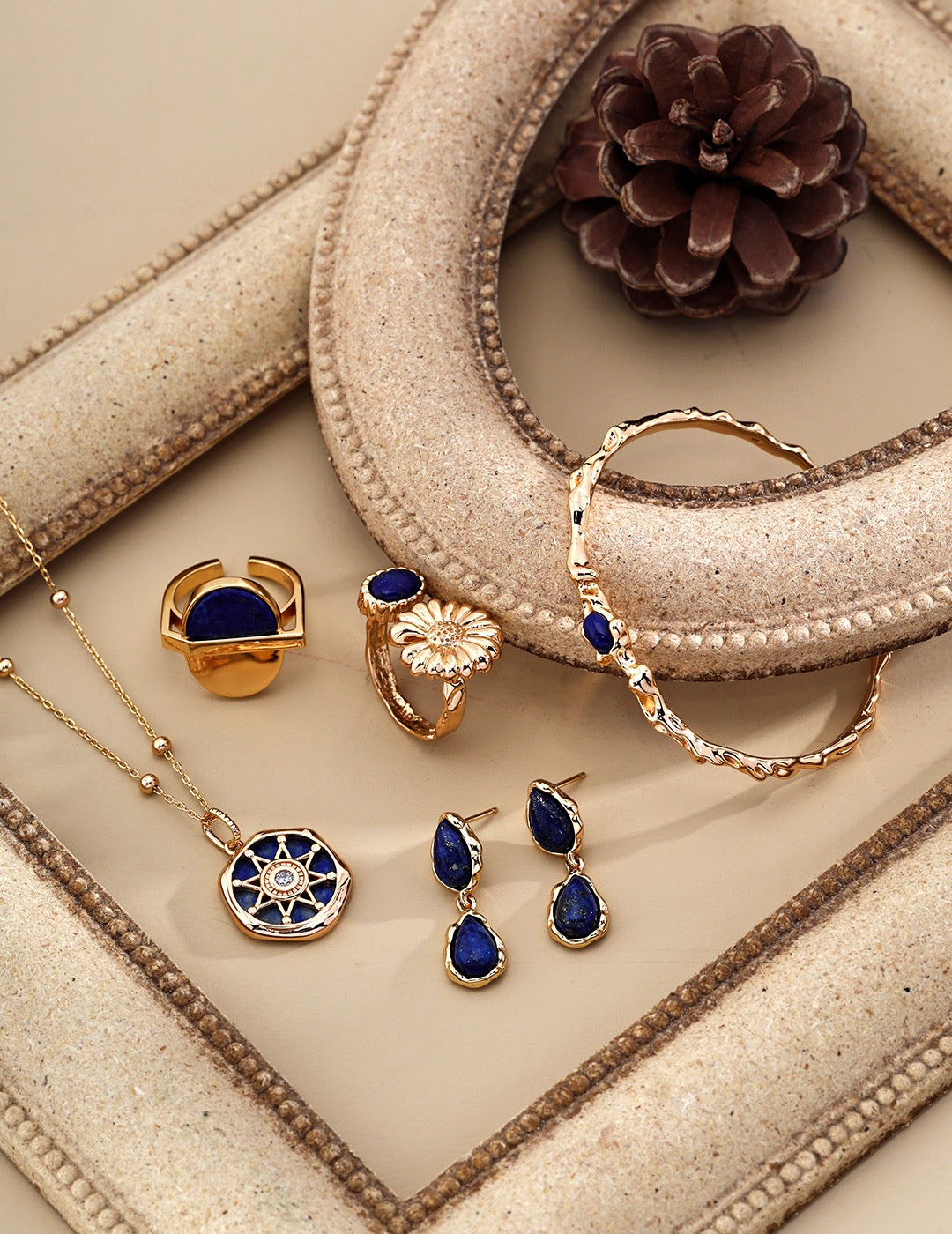 The Blue and Chry Ring with striking chrysanthemum flower and blue accents in a jewelry display setting.